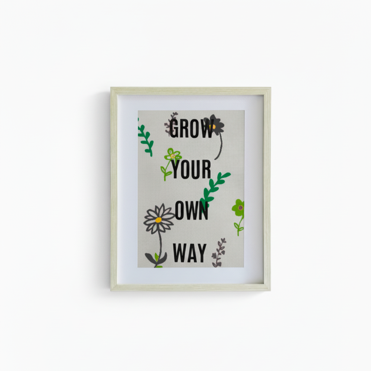 Framed artwork with motivational quote 'Grow Your Own Way' on a white background