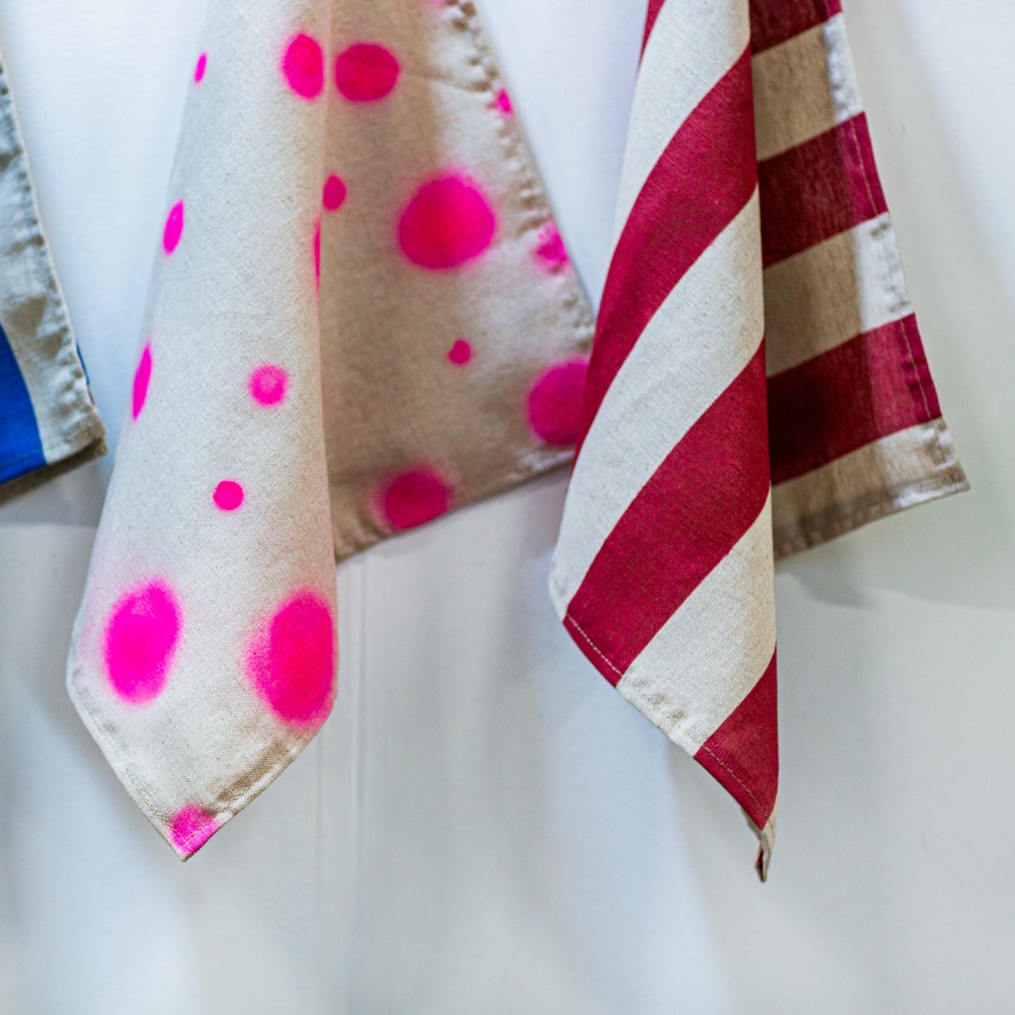 Three decorative linen naplkins with different patterns on a white background