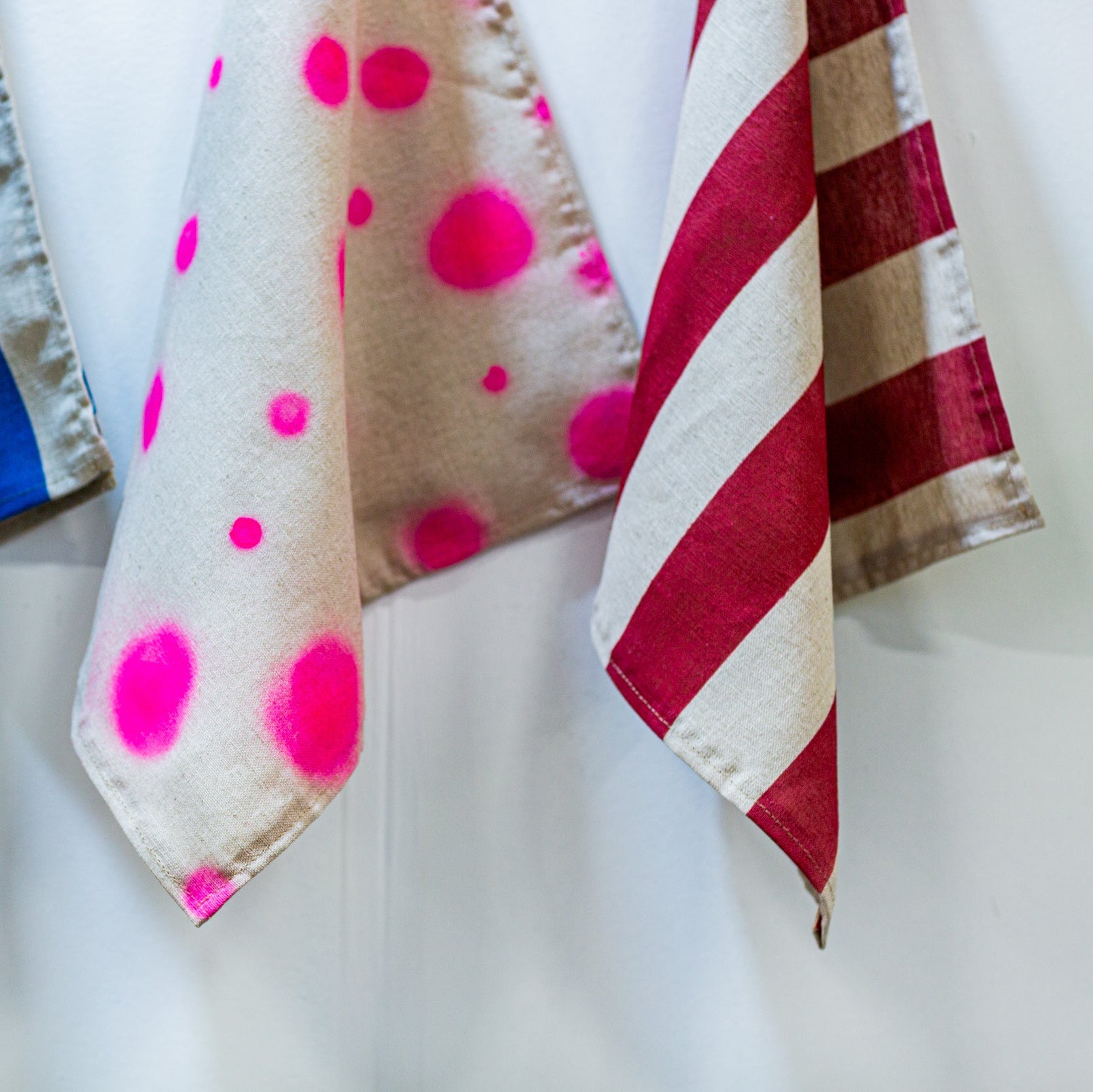 Three decorative linen naplkins with different patterns on a white background