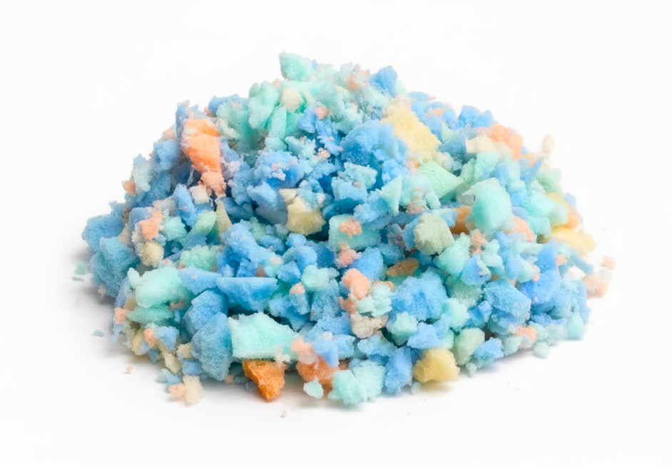 A pile of textured, crumbly foam pieces  in light blue, mint green, and peach-orange, photographed on a clean white background.