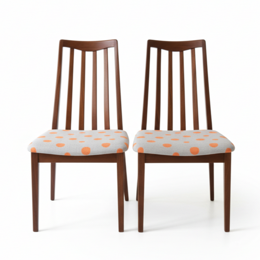 vintage g plan Two wooden chairs with polka dot cushions on a white background