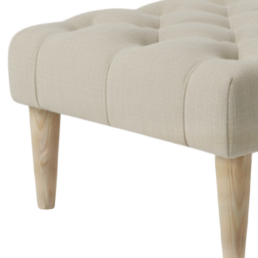 Beige upholstered bench with wooden legs on a linen fabric 